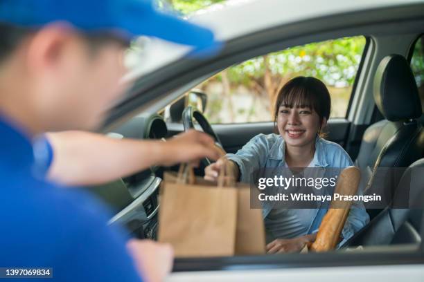 Drive through employee handing customer a bag